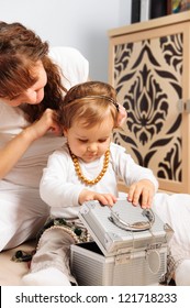 Smiling Mother And Baby Daughter Playing With Jewelry