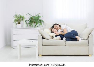 Smiling mother and daughter laying together in the living room. - Powered by Shutterstock