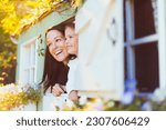 Smiling mother and daughter in playhouse window