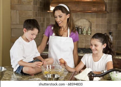 An Smiling Mother, Daughter And Son Family Cooking And Baking Chocolate Chip Cookies In A Kitchen At Home