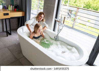 Smiling Mother Helping Daughter To Swiming Stock Photo