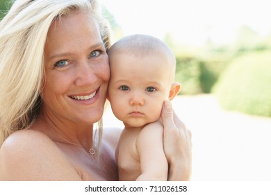 Smiling Mother Holding Baby Outdoors