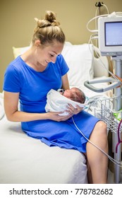 Smiling Mother Holding Her Newborn Premature Baby In The Hospital