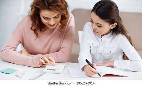 Smiling Mother And Kid Using Calculator During Homework