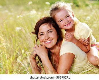 Smiling Mother And Little Daughter On Nature. Happy People Outdoors