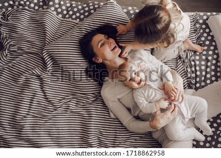 Similar – Relaxed mother and sons playing over the bed