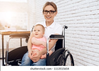 Smiling Mother In Wheelchair Hugging Newborn Baby. Disabled, Motherhood Concept.