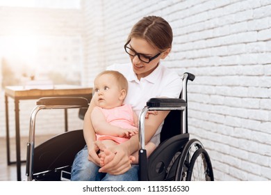 Smiling Mother In Wheelchair Hugging Newborn Baby. Disabled, Motherhood Concept.