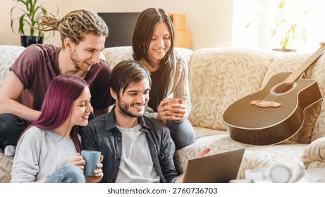 Smiling multicultural group of friends using laptop on couch, relaxing at home, browsing online, sharing moments together, friendship, entertainment and technology concept, copy space