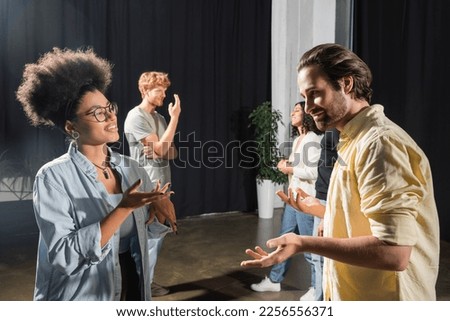 smiling multiethnic actors gesturing during conversation in acting skills school
