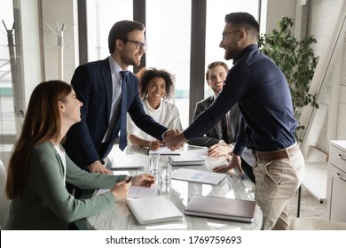 Smiling multiethnic male business partners shake hands close deal make agreement at team meeting in boardroom, excited diverse businessmen handshake get acquainted greeting at briefing in office - Powered by Shutterstock