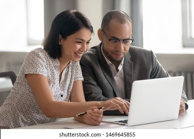 Smiling multiethnic office workers look at laptop screen talk working together on business project, happy positive male and female diverse employees collaborate using computer preparing research - Shutterstock ID 1469645855