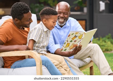 Smiling Multi-Generation Male Family Reading Book In Garden Together - Powered by Shutterstock