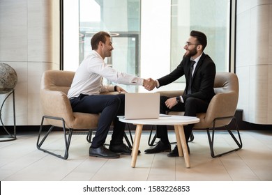 Smiling multiracial businessmen shake hands closing successful business deal at office briefing, diverse male partners handshake get acquainted greeting at meeting, partnership, cooperation concept - Shutterstock ID 1583226853