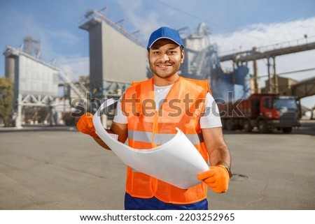 Smiling multiracial construction engineer working in plant
