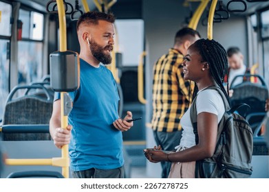 Smiling multiracial friends having fun while commuting together by a bus. Happy diverse friends talking while driving in the city bus. Friendship, public transport and people concept. Copy space. - Powered by Shutterstock