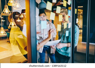 Smiling multiracial group of students enjoying lesson in language school learning words using colorful stickers, dark skinned female coach writing plan on cards during workshop meeting with employees - Shutterstock ID 1389163112