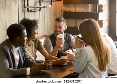 Smiling multiracial people enjoying coffee, talking spending pleasant time together in cozy coffee shop, diverse friends drinking from paper cups, meeting at work break for casual conversation in cafe - Powered by Shutterstock