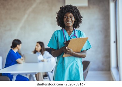 A smiling nurse holding a clipboard in a contemporary healthcare environment, with colleagues discussing in the background. Represents professionalism, teamwork, and confident healthcare service. - Powered by Shutterstock