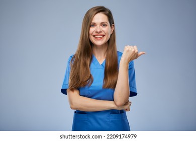 Smiling Nurse Woman Pointing Thumb At Side. Isolated Female Portrait.