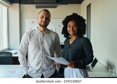 Smiling Office Workers Stand Side By Side In The Middle Of The Office