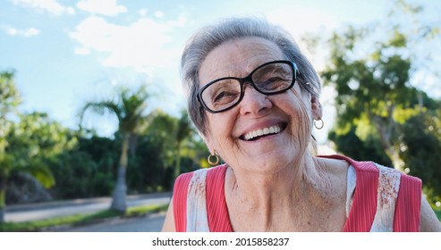 Smiling Old Latin Woman. Beautiful Senior Woman Looking At The Camera With A Warm Friendly Smile And Attentive Expression. Elderly Woman Laughing.