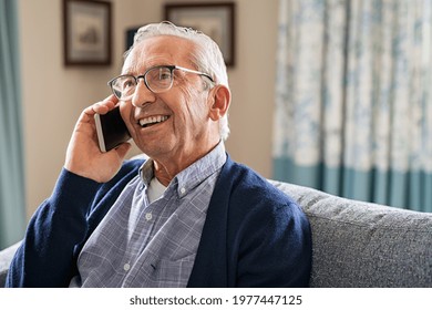 Smiling old man talking over smartphone while relaxing at home. Senior man after retirement using smart phone to connect with friends and family. Carefree elder talking over phone with her daughter. - Powered by Shutterstock