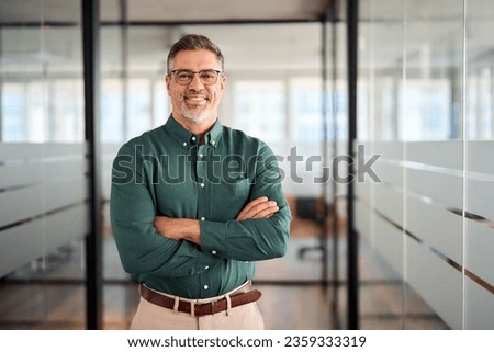 Smiling older bank manager or investor, happy middle aged business man boss leader, confident mid adult professional businessman executive standing in office hallway, mature entrepreneur portrait.