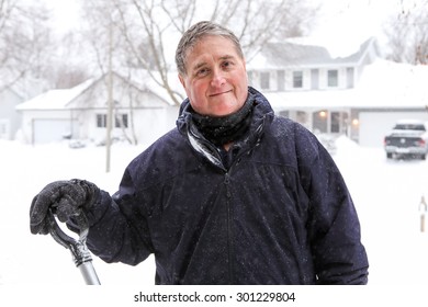 Smiling Older Man Shoveling Snow In Winter.