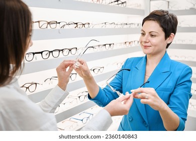Smiling optical shop customer picking out new glasses