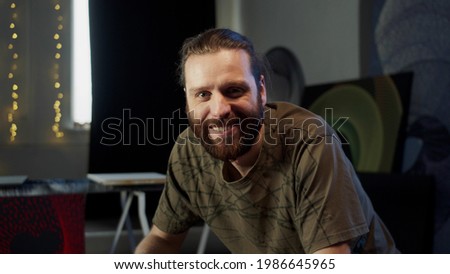 A smiling painter is looking at the camera 