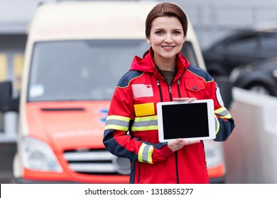 Smiling Paramedic In Red Uniform Holding Digital Tablet With Blank Screen