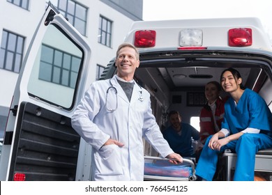 Smiling Paramedic Team With Working Car