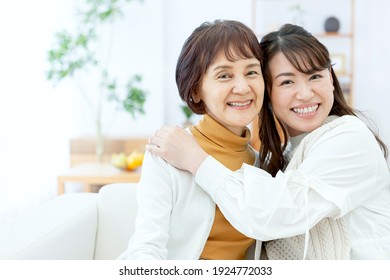 A smiling parent and child relaxing in the living room