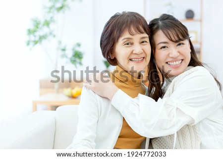 A smiling parent and child relaxing in the living room