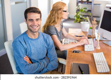 Smiling partners sitting together at desk in the office