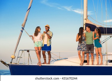 Smiling People On Yacht Deck. Young Men Hugging Women. In The Center Of Attention. Having Fun With Good Friends.