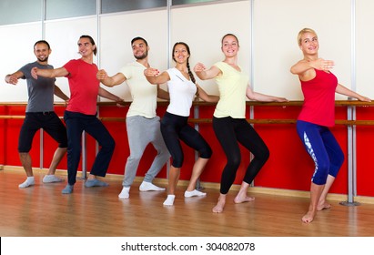 Smiling people rehearsing ballet dance in studio
