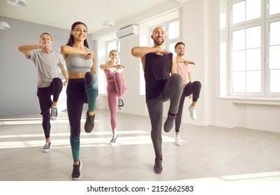 Smiling people in sportswear do sports exercise in bright studio. Happy young dancers crew or team train dance together. Hobby and entertainment concept. Physical activity and workout. - Powered by Shutterstock