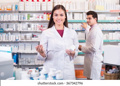 Smiling Pharmacist And Pharmacy Technician Posing In Drugshop