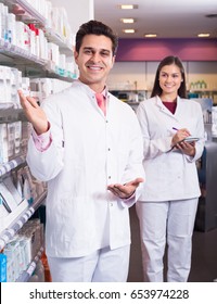 Smiling Pharmacist And Pharmacy Technician Posing Indoor