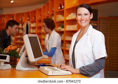 Smiling Pharmacist Working At Computer In A Pharmacy