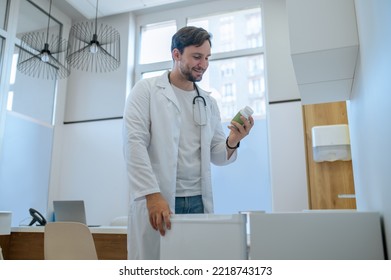 Smiling Physician Reading The Label On The Dietary Supplement