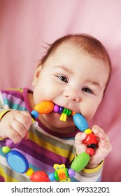 Smiling And Playing Baby With Teething Ring. Closeup Face.