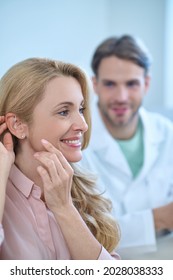 Smiling pleased female admiring her new hearing device