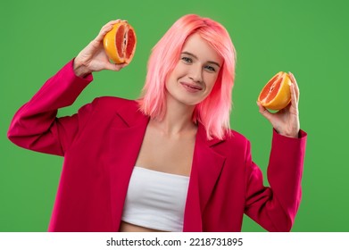 Smiling Pleased Girl With A Nose Ring Showing Citrus Fruit