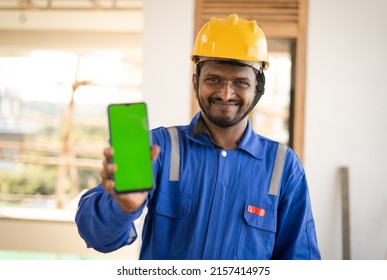 smiling plumber showing mobile phone with green screen mockup by lookling at camera - concept of booking of house repair service, app advertising and blue collar jobs - Powered by Shutterstock