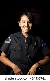 A Smiling Police Officer Posing For Her Portrait In The Night.