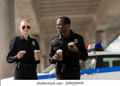 Smiling Police Officers Having Coffee Break With Doughnuts