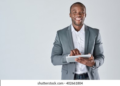 Smiling Portrait Of Black Businessman With Touchscreen Tablet Device In Business Suit Isolated In Studio